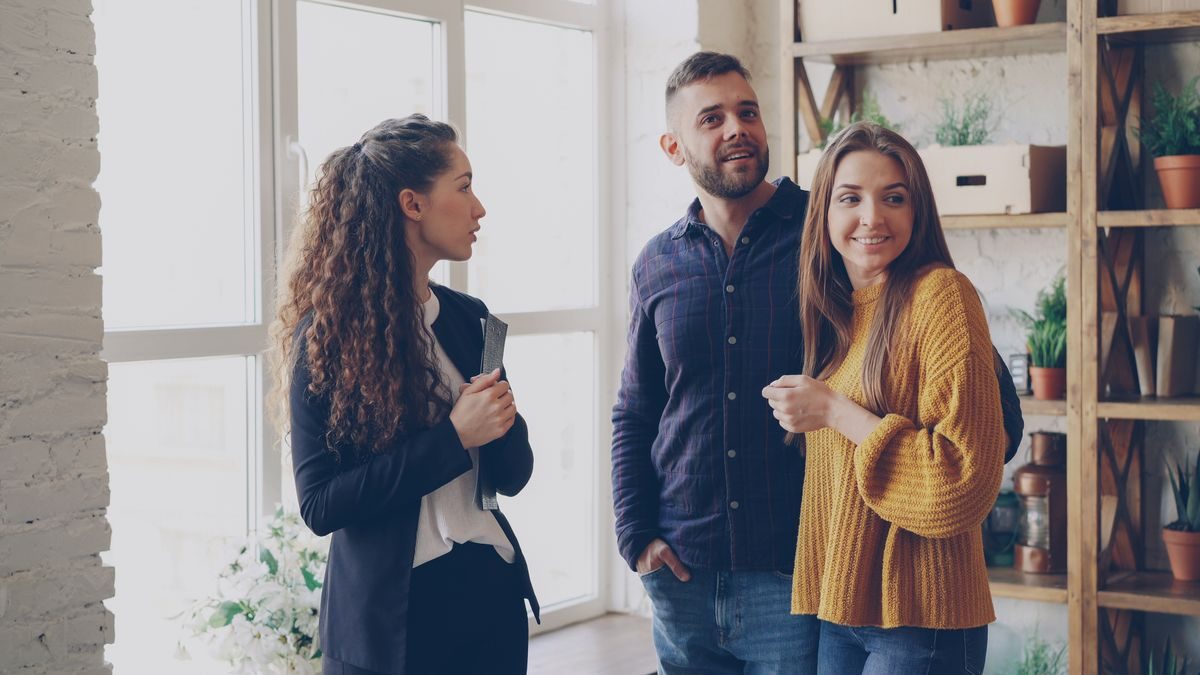 IA para agencias inmobiliarias: agente inmobiliaria enseñando un piso a una pareja