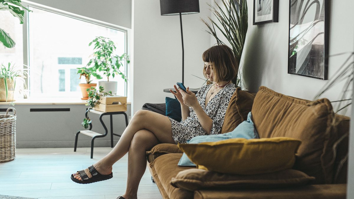 Chatbot de WhatsApp para inmobiliarias: clienta escribiendo a una agencia desde el sofá