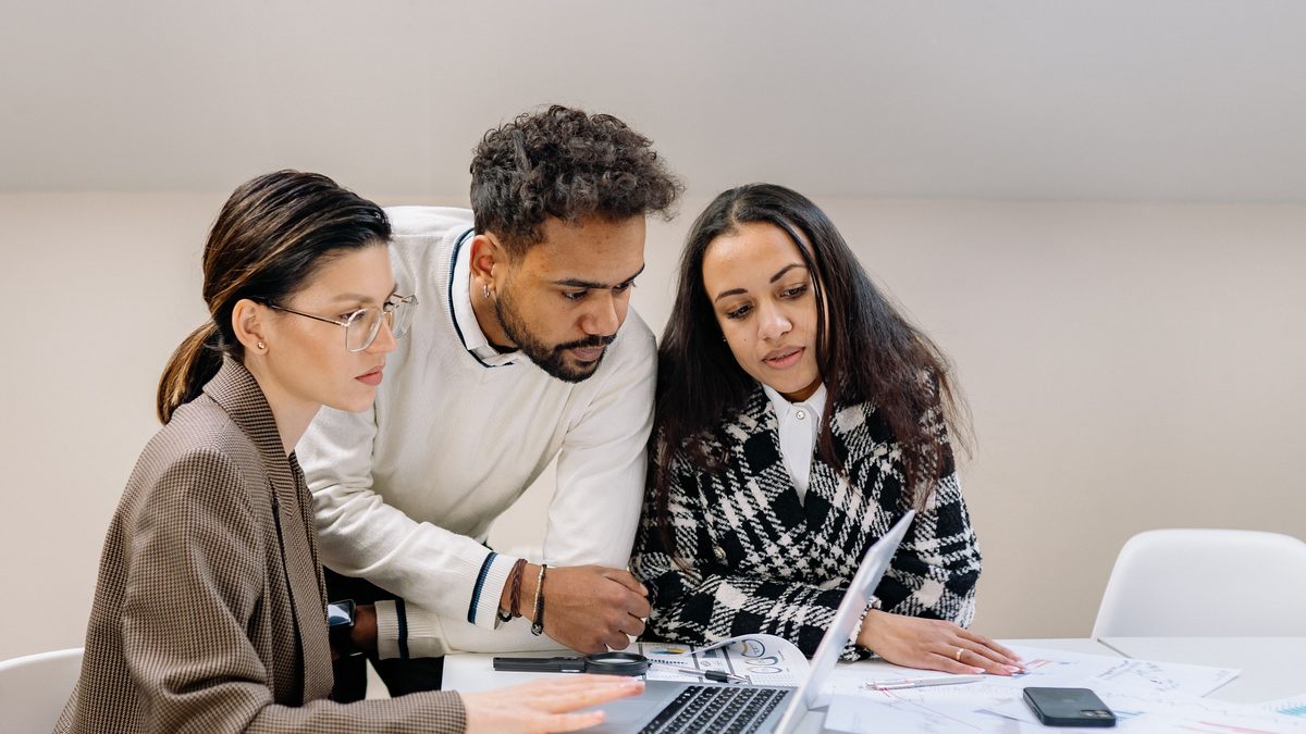 CRM inmobiliario con IA: equipo de una agencia revisando clientes y pisos en un portátil