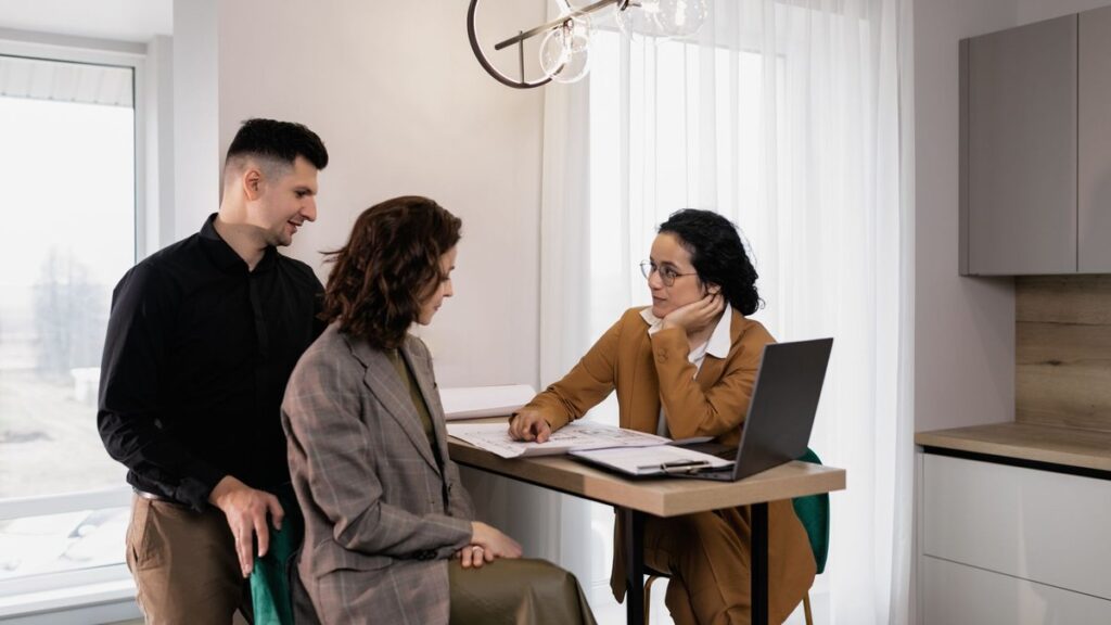 Cualificar compradores: agente inmobiliario atendiendo a una pareja interesada en un piso